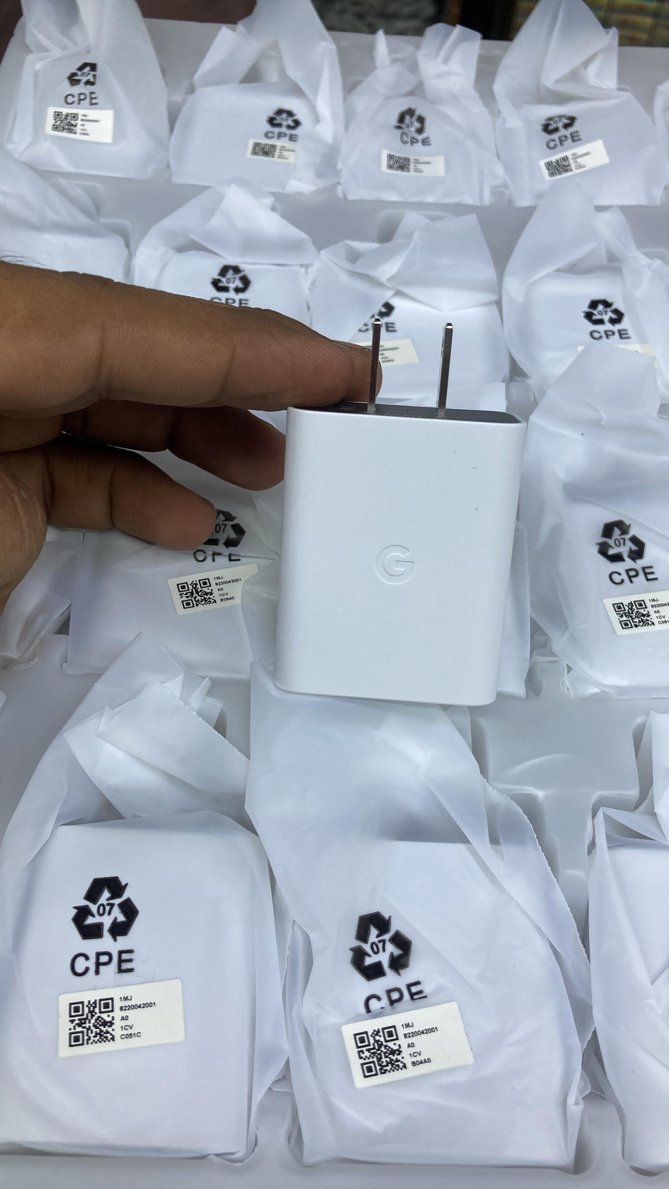 Side view of genuine white Google Pixel 30W charging adapter featuring the embossed official G logo.