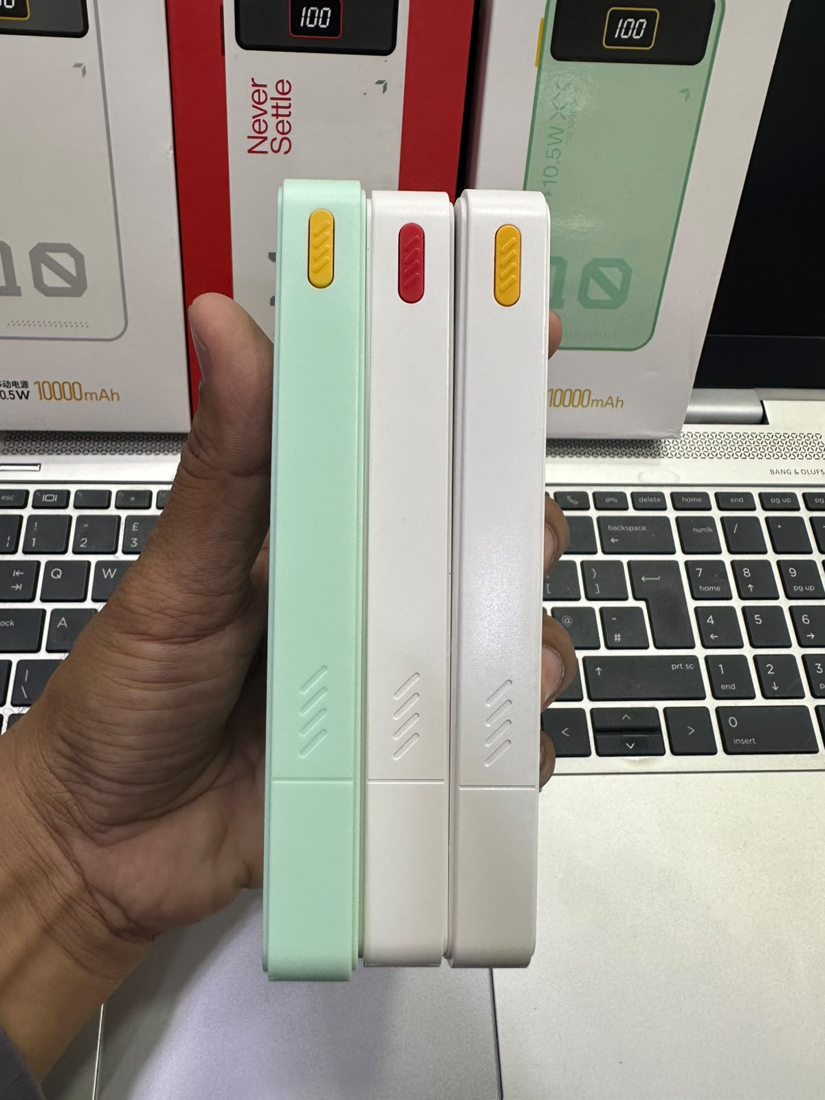 Hand holding multiple Yevon 10000mAh power banks showcasing slim design M F Chargers