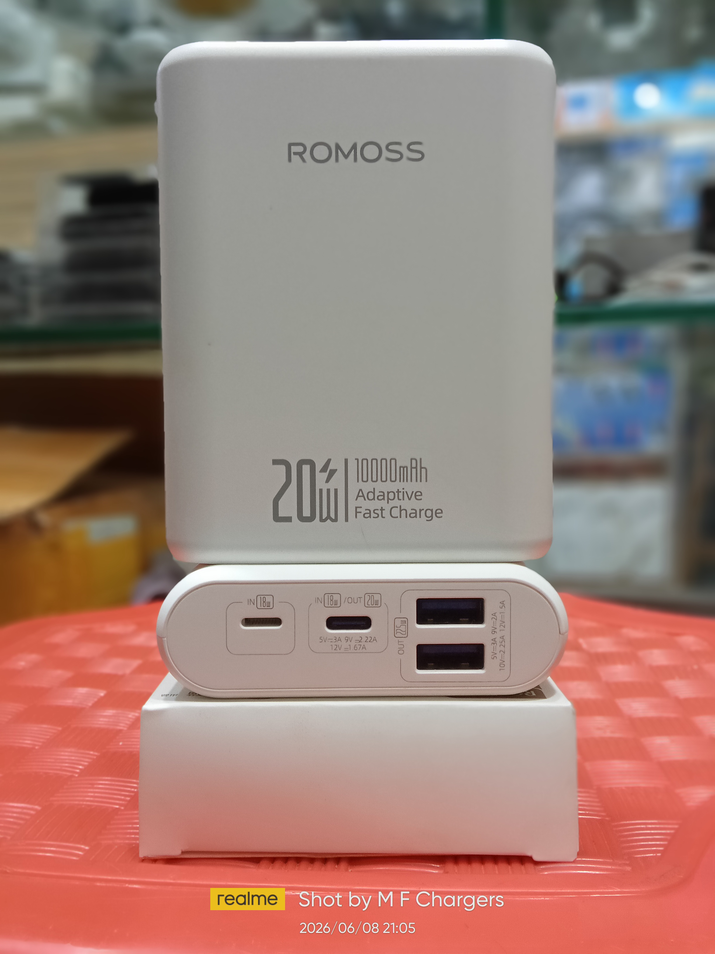 Front and port interface view of authentic white Romoss 20W 10000mAh adaptive fast charge power bank placed on its retail box.