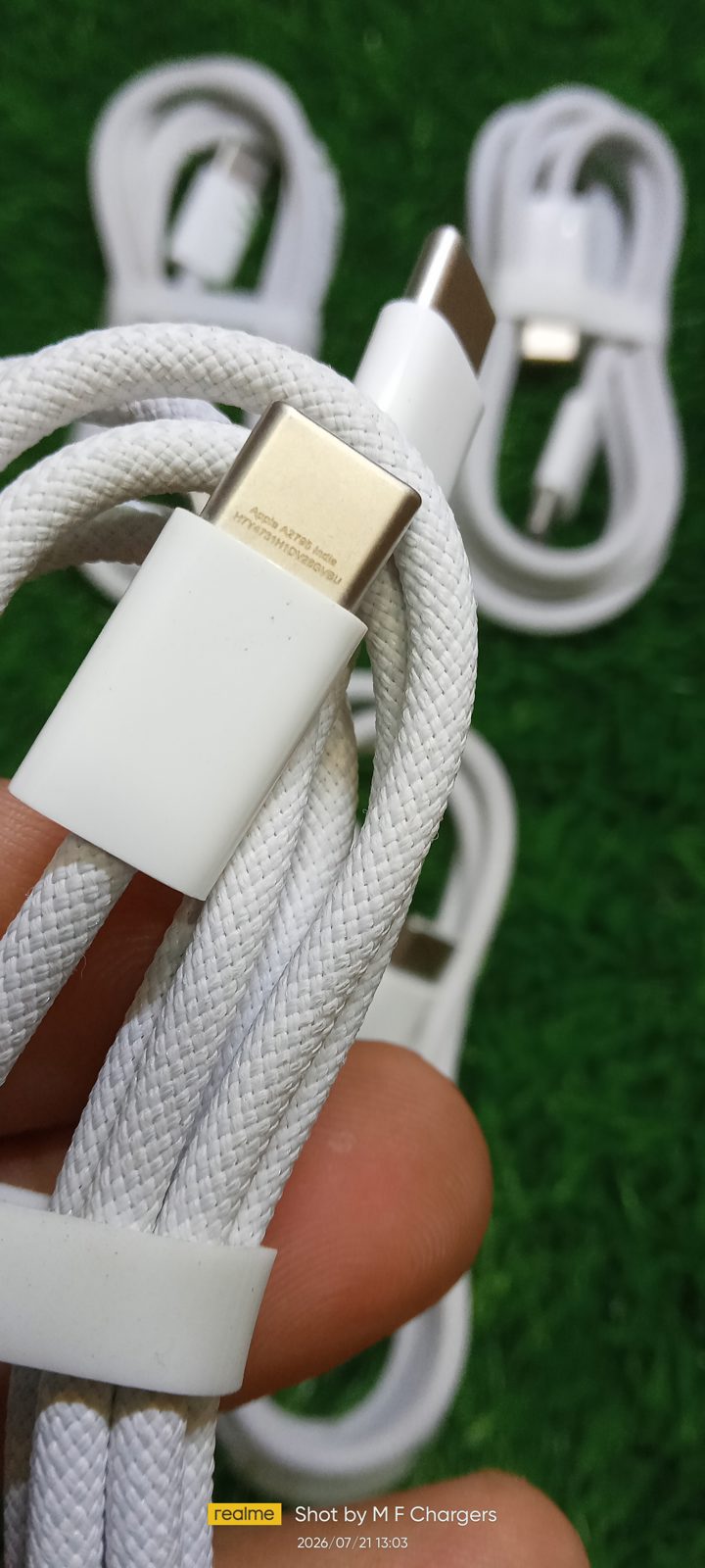 Hand holding Apple Braided Type-C connector showing model code A2795 and India text on connector housing at M F Chargers