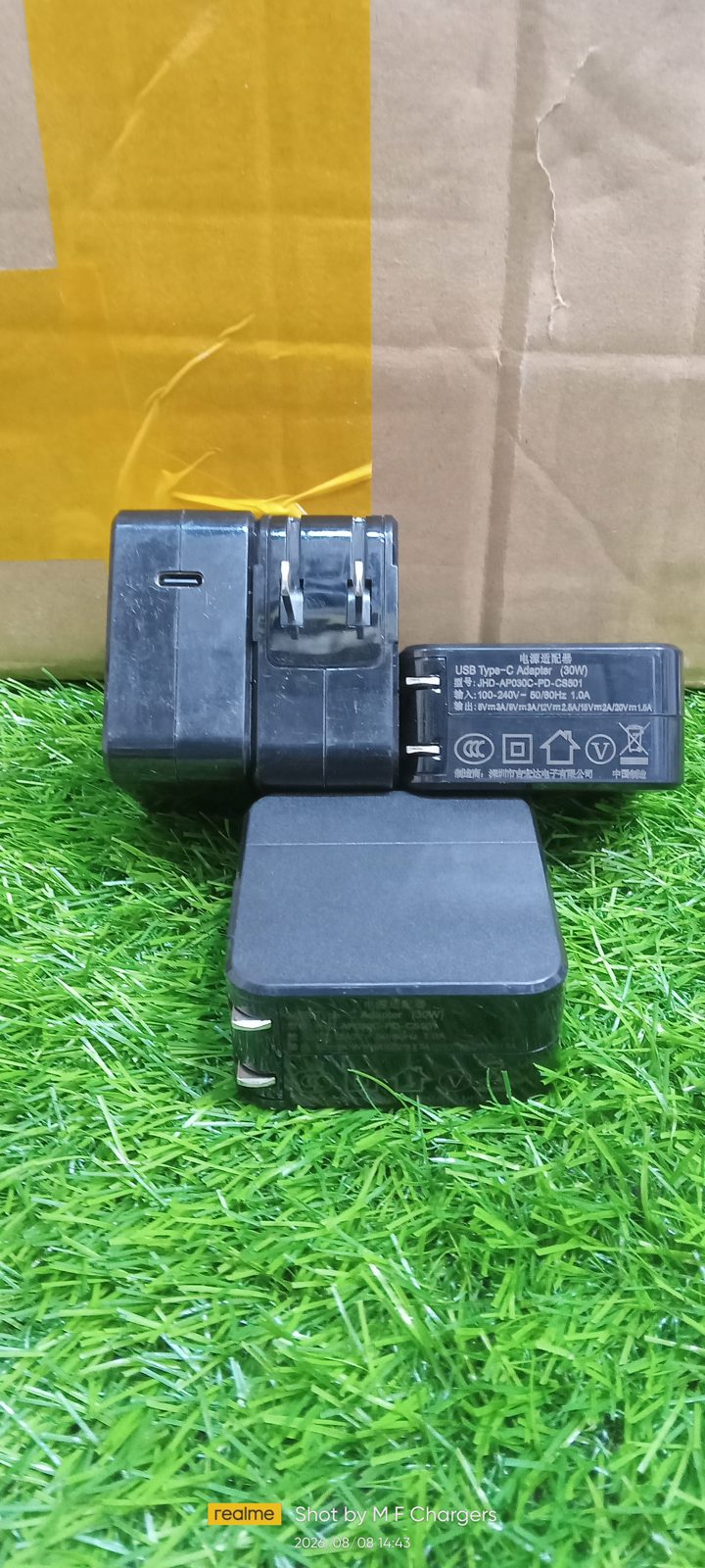 ​M F Chargers stock display of multiple 30W Type-C fast power adapters on green turf.