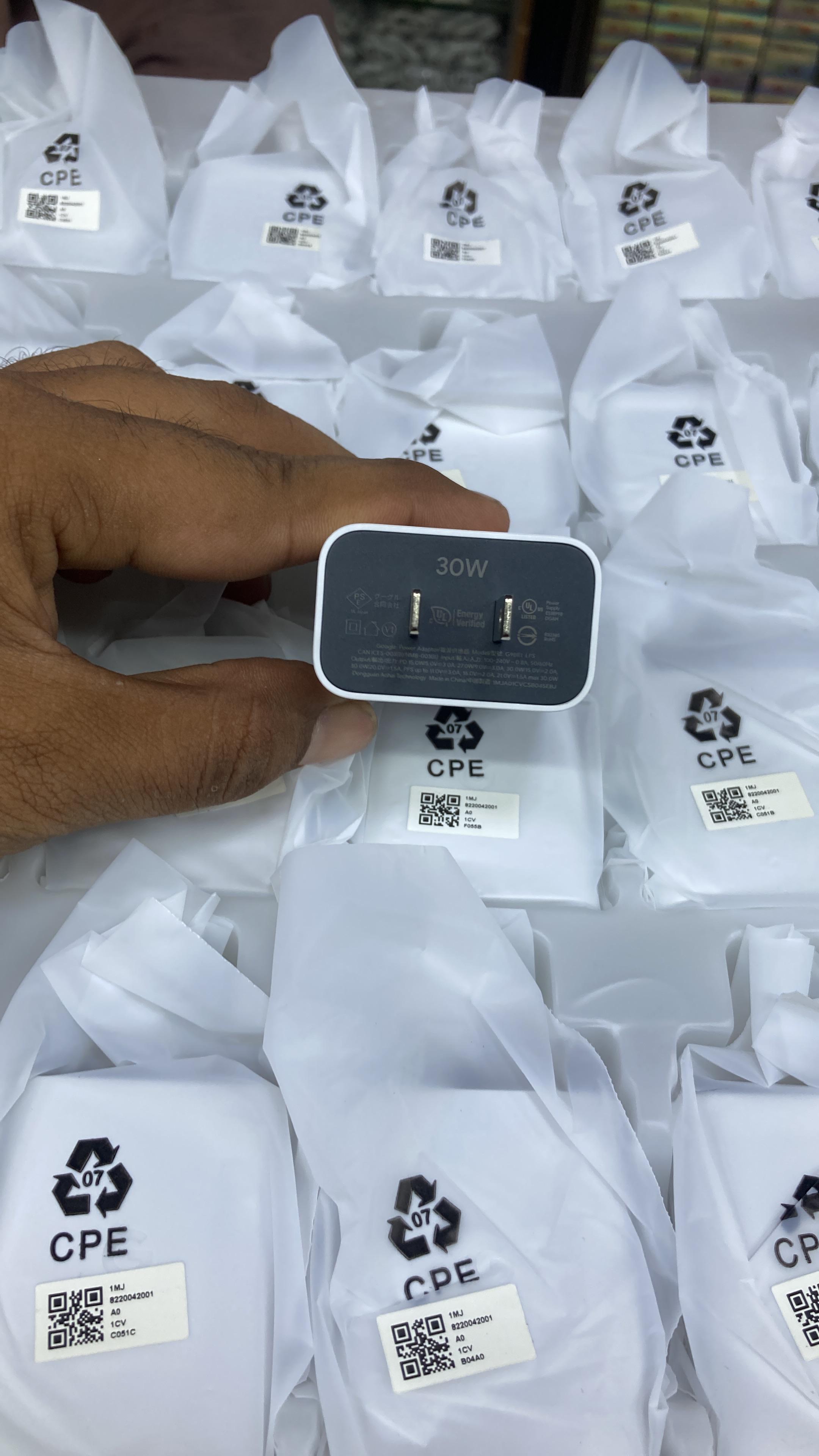 Original Google Pixel 30W charger adapter bottom side showing power specifications with a background of CPE wrapped stock.
