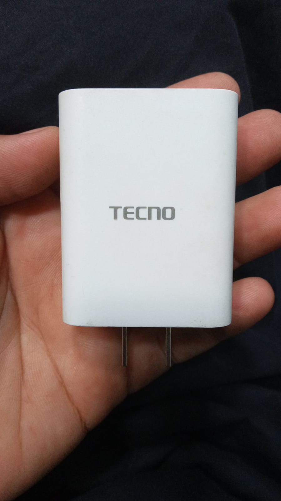 Front view of authentic white Tecno mobile charger adapter with official TECNO logo printed on the body.