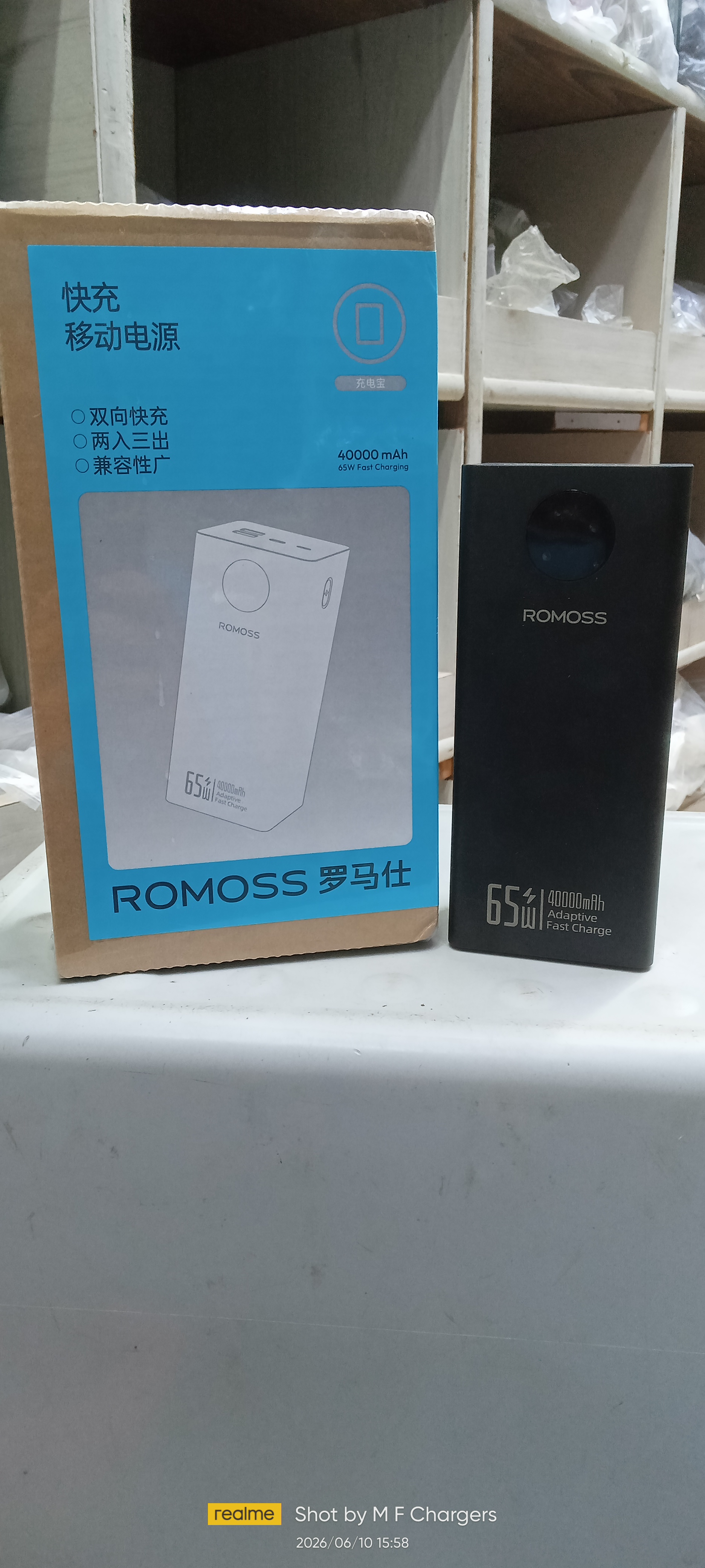 Authentic Romoss 65W 40000mAh adaptive fast charge power bank placed next to its blue and brown retail packaging box.